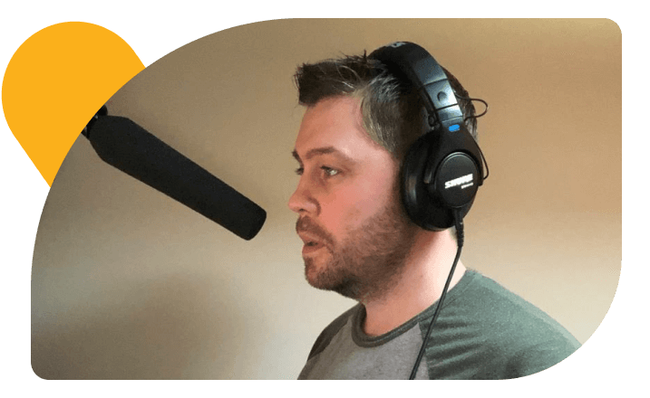 Professional voice talent Marc Scott wearing headphones in his recording studio.