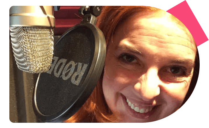 Voice actor Shana Pennington-Baird smiling behind a professional studio microphone.